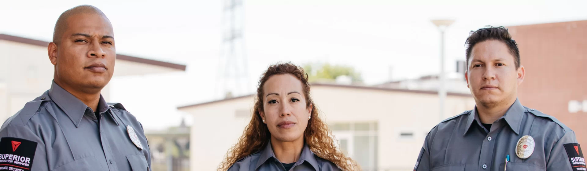 Three uniformed security officers standing confidently, representing top-tier security services for businesses and organizations.