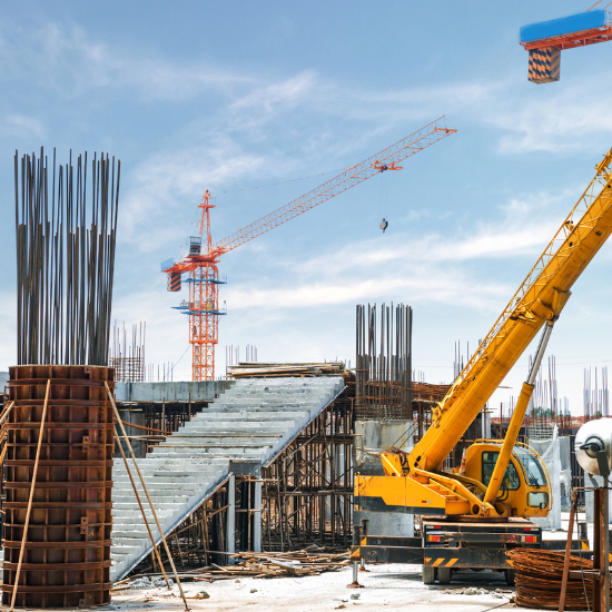 A picture of a yellow crane in a construction site being protected by Superior Protection Services, a company providing security services for companies in the construction industry.