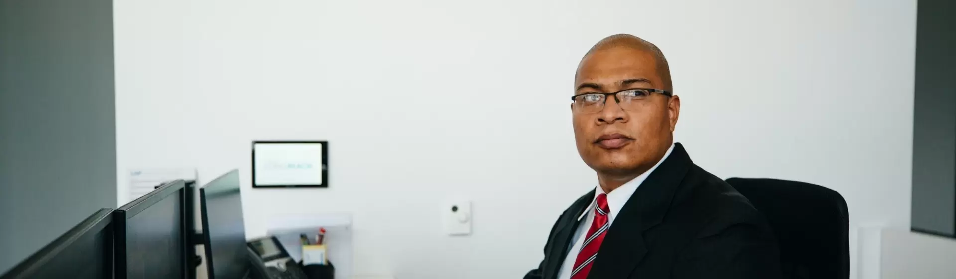 Professional security officer in a suit working at an office desk, representing high-quality security services.